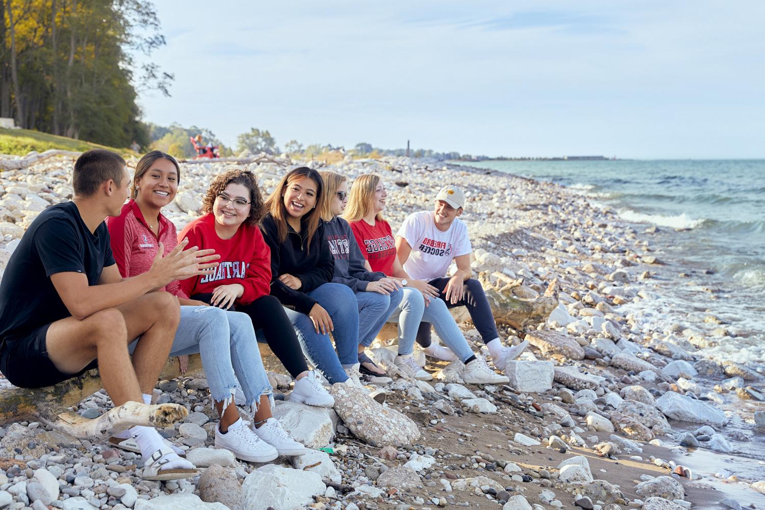 Friends gather at the lakefront to enjoy a summer day on campus.
