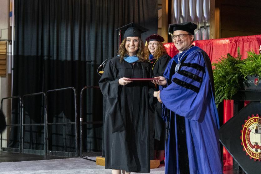 A graduate receives her diploma from President Swallow. 